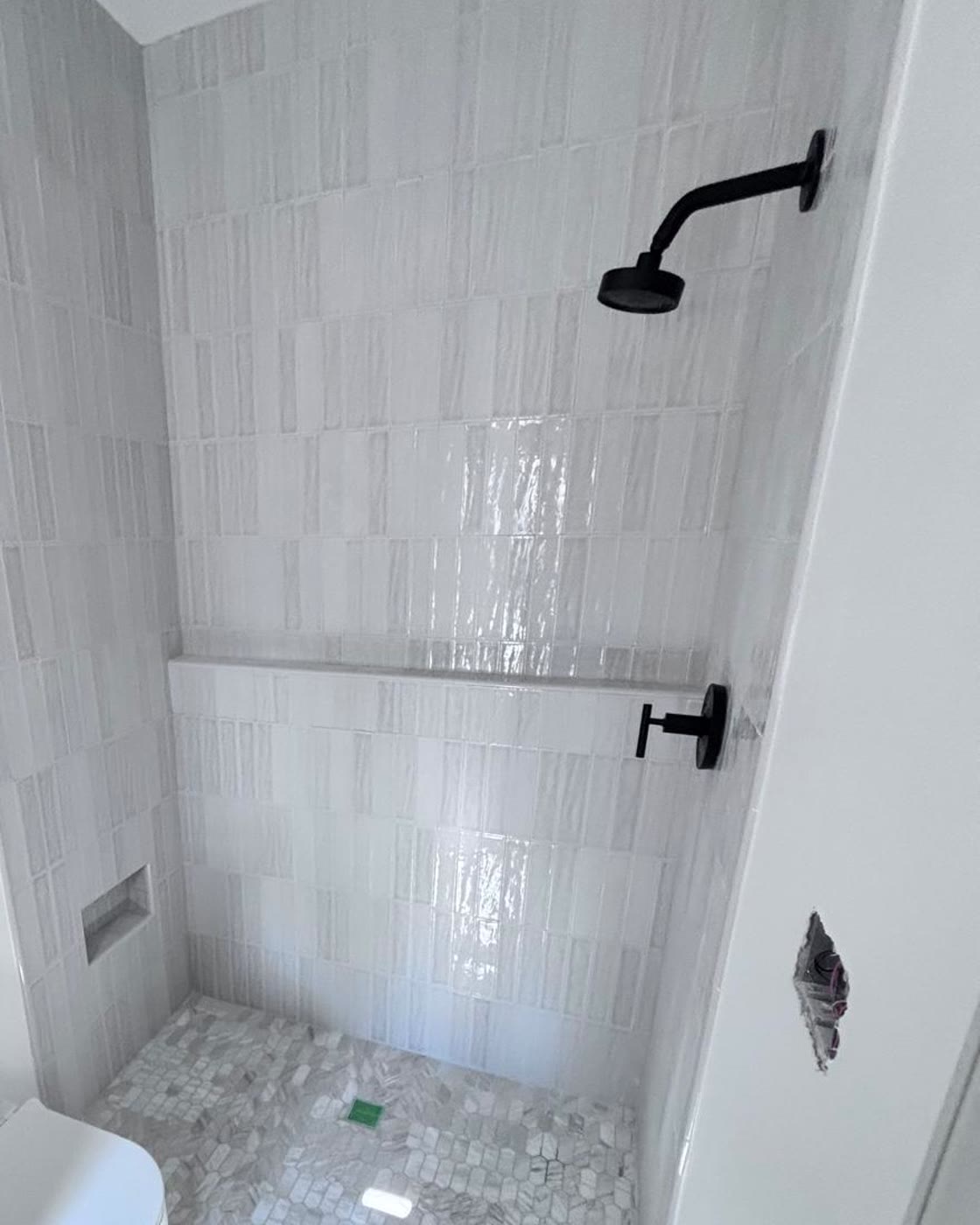 Linear tile shower with hexagon mosaic floor